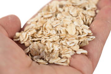 healthy eating, dieting, vegetarian food and people concept - close up of hands holding oatmeal flakes at home