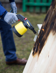 Man working outdoor. Man roasting wooden boards with gas-burner