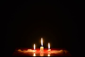 burning candles on isolated black background