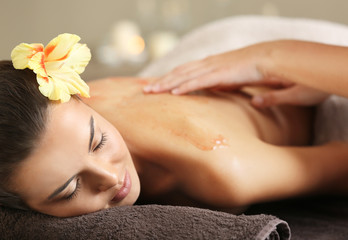 Obraz na płótnie Canvas Young woman receiving scrub massage in spa salon