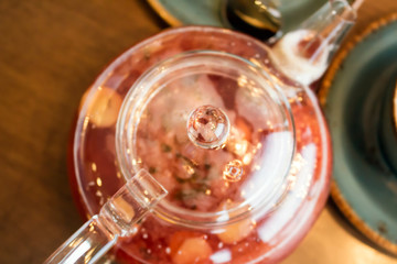 Kettle with aromatic, warming tea with raspberries, ginger and spices close-up