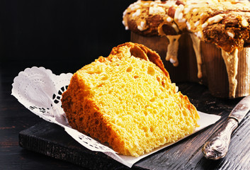 Slice of Colomba - italian easter dove cake on old rustic black wooden board. Selective focus, free text space.
