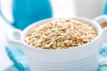Rolled oats on white wooden background