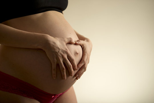 Pregnant woman holding her bare belly