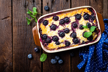 Blueberry cheesecake on dark wooden rustic backgroud, top view