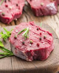 Pieces of beef tenderloin on the wooden cutting board.