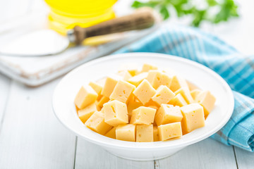 Cheese slices on plate, white background