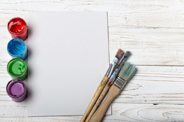 Artist's workshop. Canvas, paint, brushes, palette knife lying on the table.Art tools.Artist workplace background.Acrylic paint and brushes.Art picture with copy space and for add text.