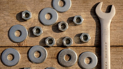 spanner nut and washers on a wooden background