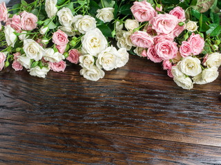 Delicate fresh roses on the wooden background.