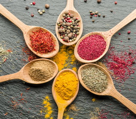 Assortment of colorful spices in the wooden spoons.