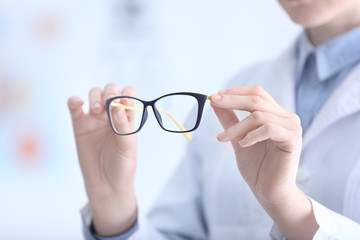 Doctor hands holding glasses on blurred background