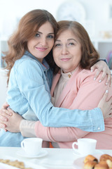 Adult daughter hugging an elderly mother
