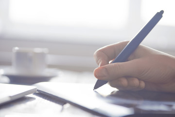 Person using stylus on graphic tablet with computer