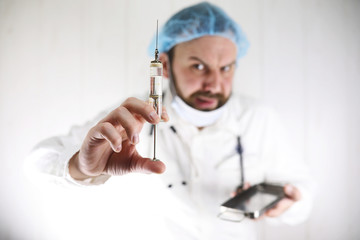 Naklejka premium Crazy bearded doctor in a white coat and old syringe
