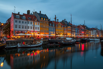 Fototapeta na wymiar COPENHAGEN, DENMARK - 25 JUN 2016: Fairy tale Nyhavn canal at blue hour, illumanated houses and street