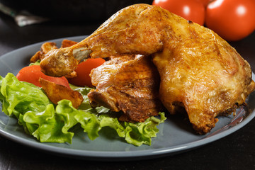 Roasted chicken legs with potato wedges and tomatoes