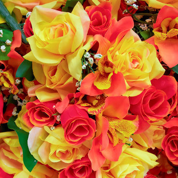 orange and yellow fake roses, floral background