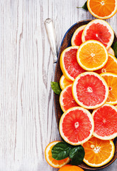 Fototapeta na wymiar Variety sliced citrus fruit orange, grapefruit, lemon on wooden board. Top view.