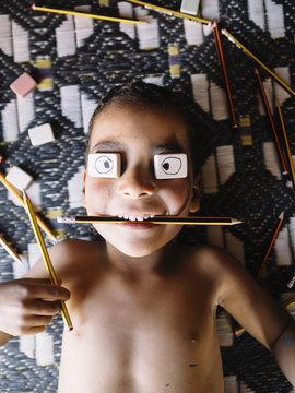 Child with rubbers and pencil�on face