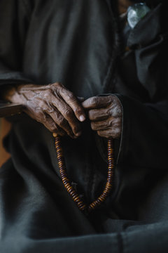 Midsection of man holding beads talisman