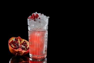 Cocktail in a glass goblet on a black background.