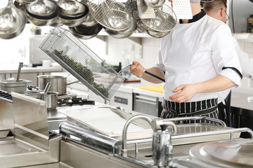 Chef in hotel or restaurant kitchen cooking
