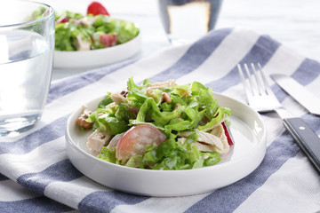 Plate with chicken salad and grapes on table