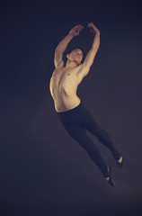 Handsome young ballet dancer on dark background