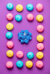 photo of tasty colorful marshmallows and dotted bow on the wonderful purple background