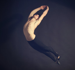 Handsome young ballet dancer on dark background