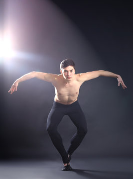 Handsome young ballet dancer on dark background