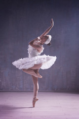Fototapeta premium Young beautiful ballerina dancing in studio