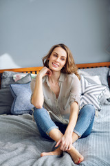 Obraz premium Young beautiful girl resting on bed at home. The concept of a lifestyle and family