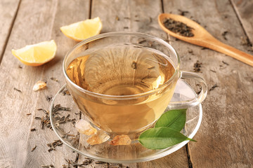 Cup of aromatic tea on wooden background