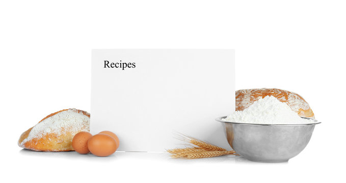 Sheet of paper with text RECIPES and bread on white background