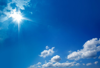cloudscape image of clear blue sky with shining sun.