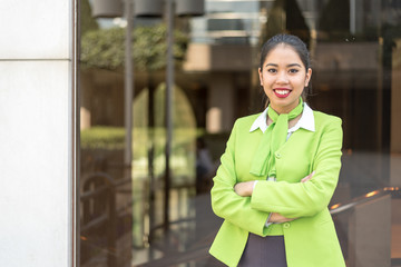 young hostess woman or stewardess smiling crossed arms green