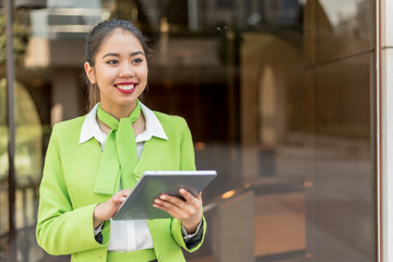 young hostess woman or stewardess smiling crossed arms green