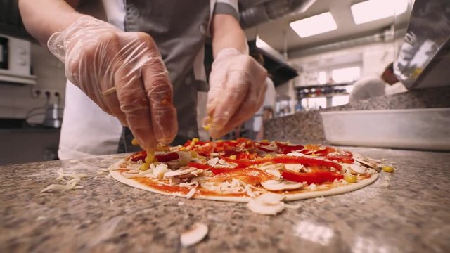 Chef prepares pizza, ingredients for pizza, tomato paste, cheese, red pepper. Close-up. 4k footage.
