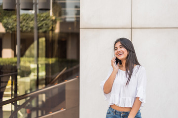 young happy Woman talikng and texting message with her mobile phone