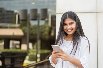 young happy Woman talikng and texting message with her mobile phone