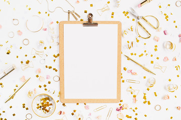 Beauty blog background. Clipboard and gold style feminine accessories pattern. Golden tinsel, scissors, pen, rings, necklace, bracelet on white background. Flat lay, top view.