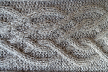 Close-up of plait pattern on grey handmade knit fabric
