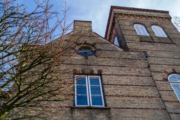 old brick house from below against blue sky