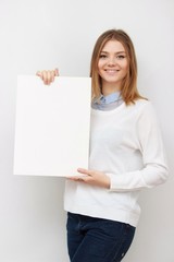 Young smiling woman show blank card or paper