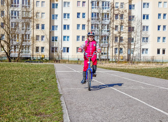 little girl in a safety helmet riding a bicycle