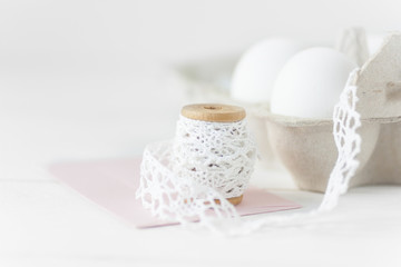 Easter eggs on white woode with pink envelope