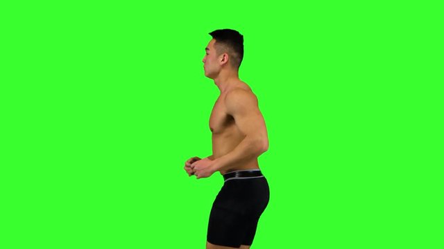 Athlete man runs on the green screen background. Side view