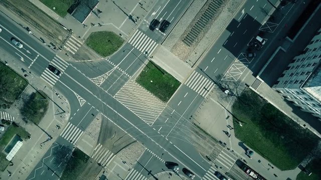 Aerial shot of urban road intersection on a sunny day, top view. 4K video